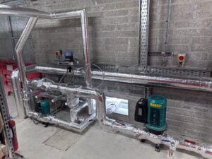 Industrial pipework with circulation pump and dirt separator insulated with foiled fiberglass