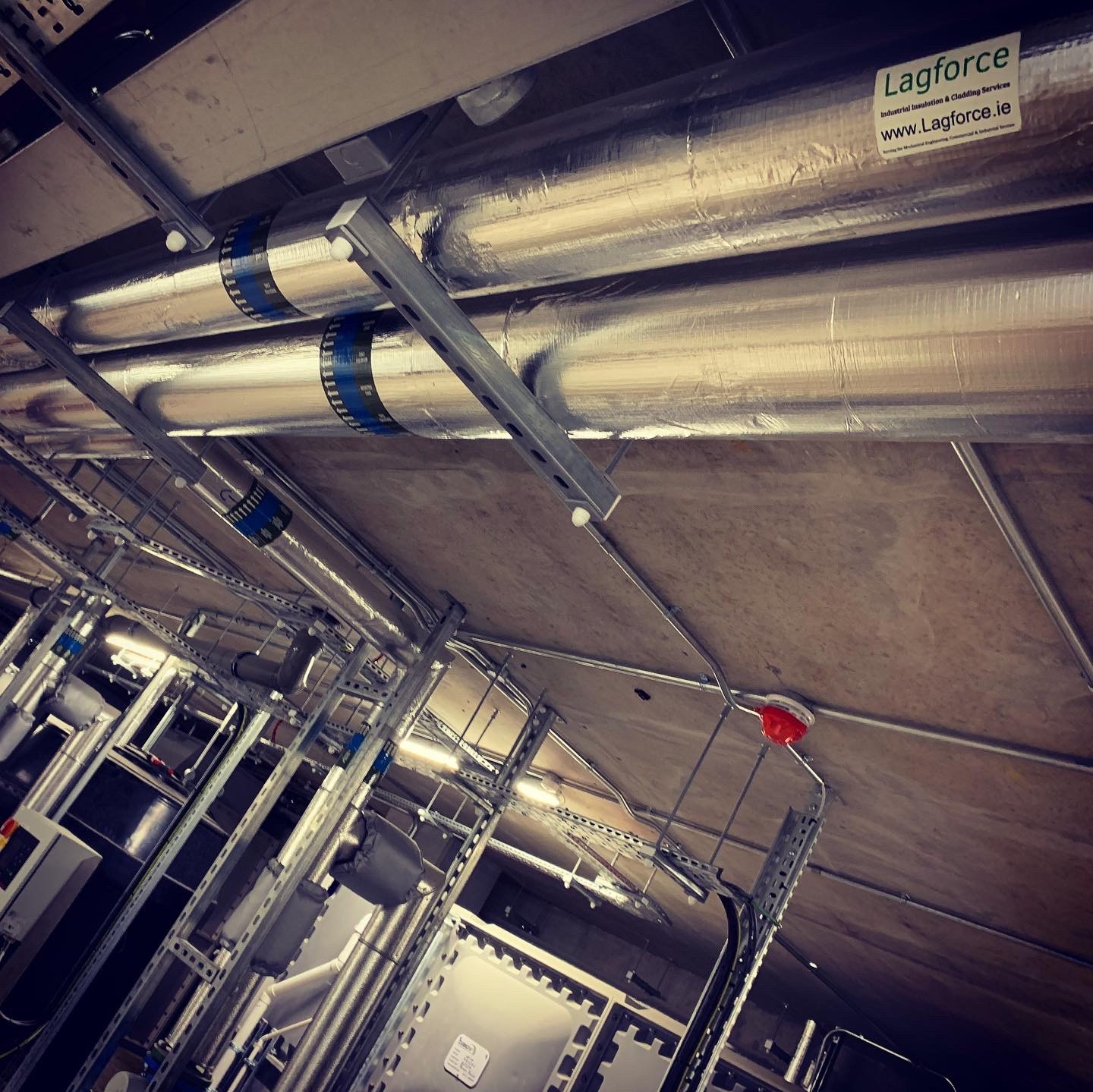 Insulated overhead pipework in a building services area