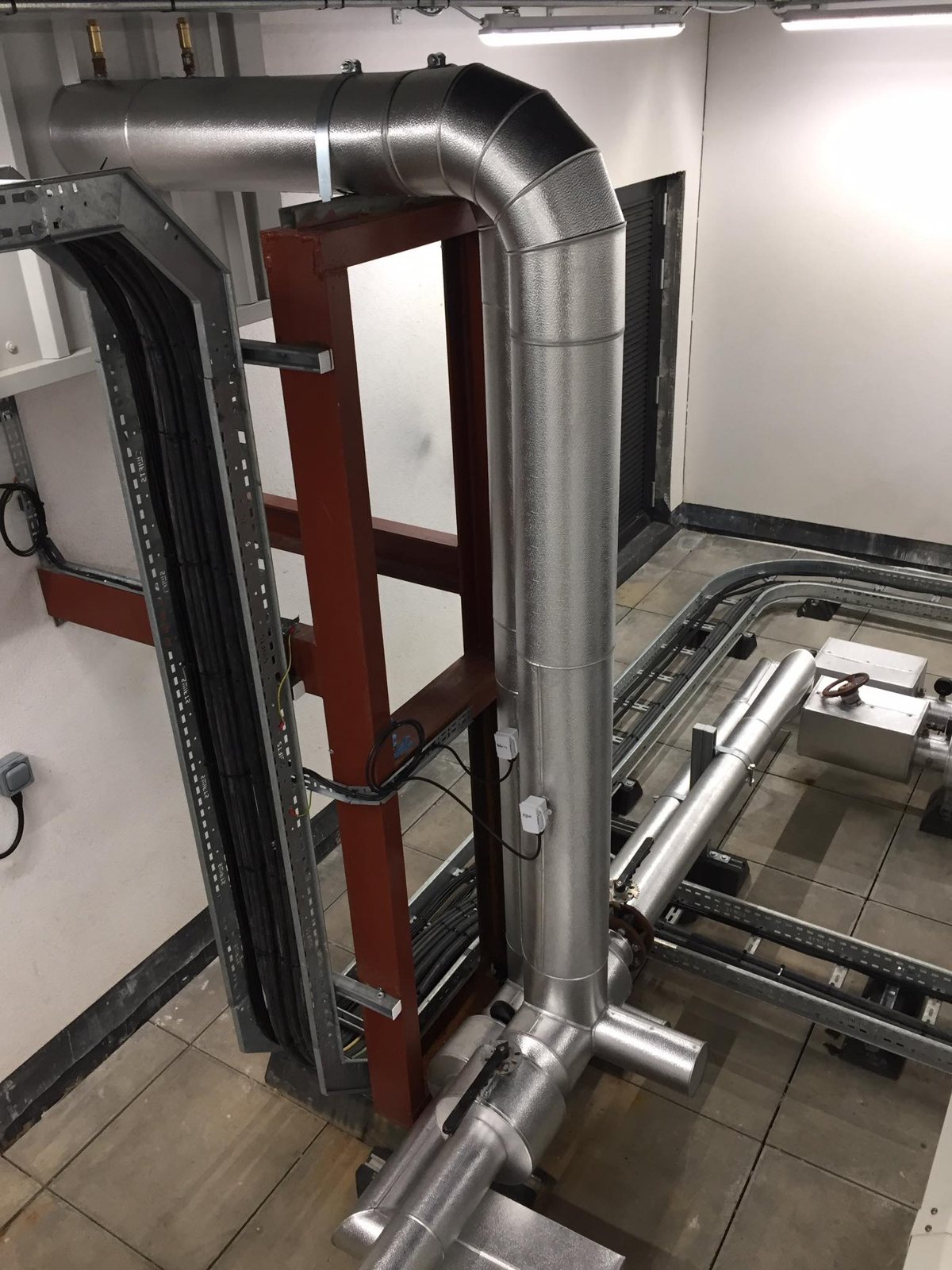 Formed metal cladding around insulated risers, bends and connecting pipework.