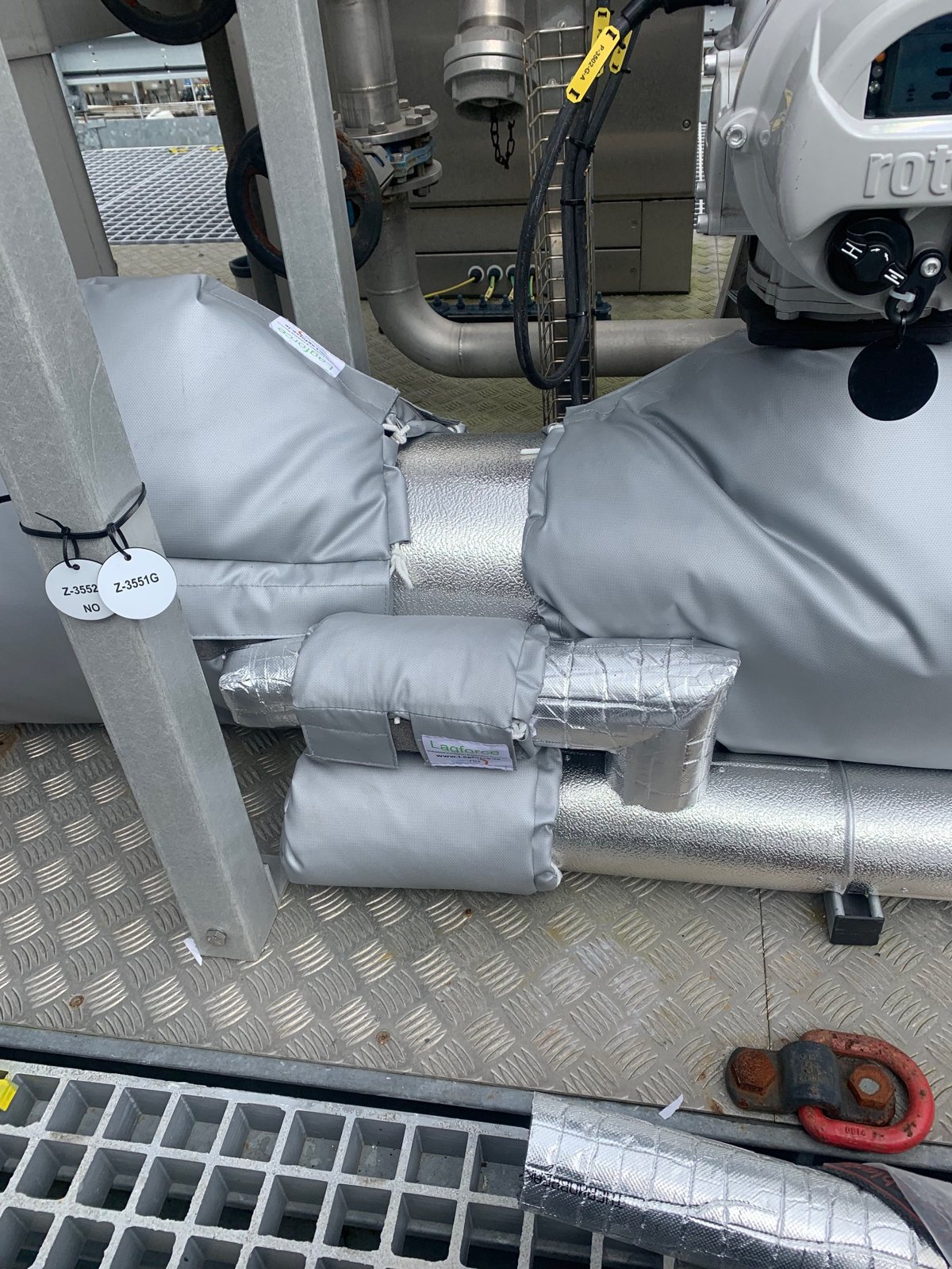 Removable insulation covers around valves and fittings beside chiller plant.