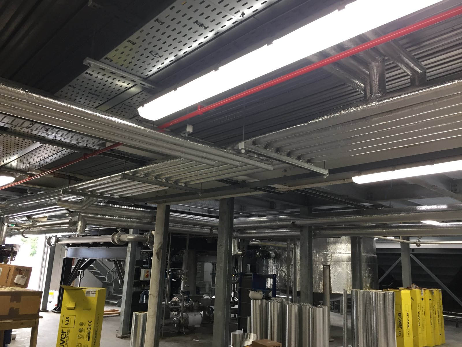 Insulated overhead pipework serving a distillery installation.