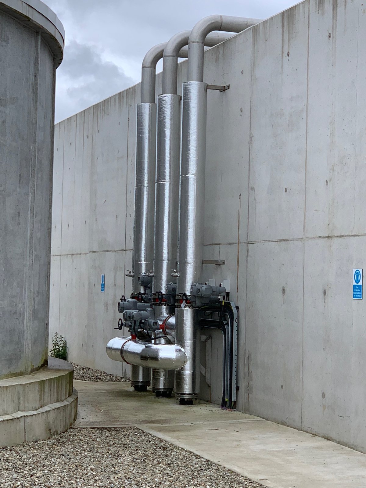 Protective cladding on external vertical pipework and connecting bends.