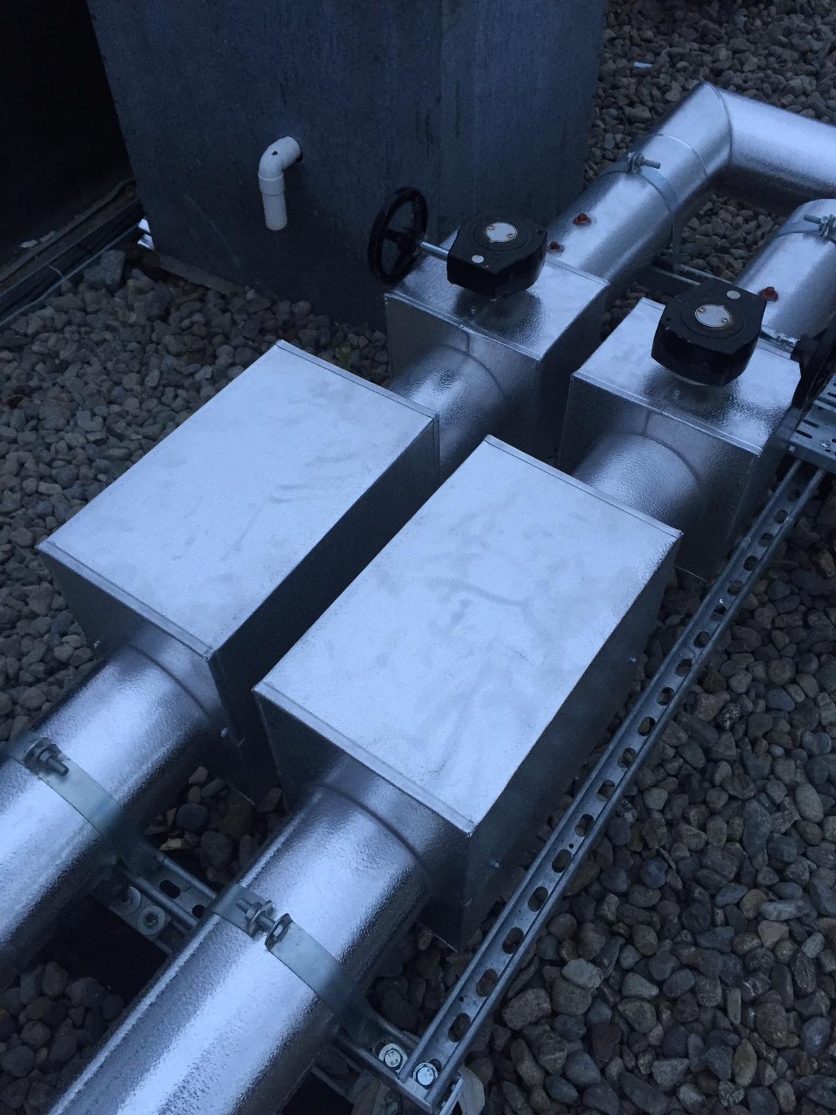 Removable metal access covers over fittings on external insulated pipework.