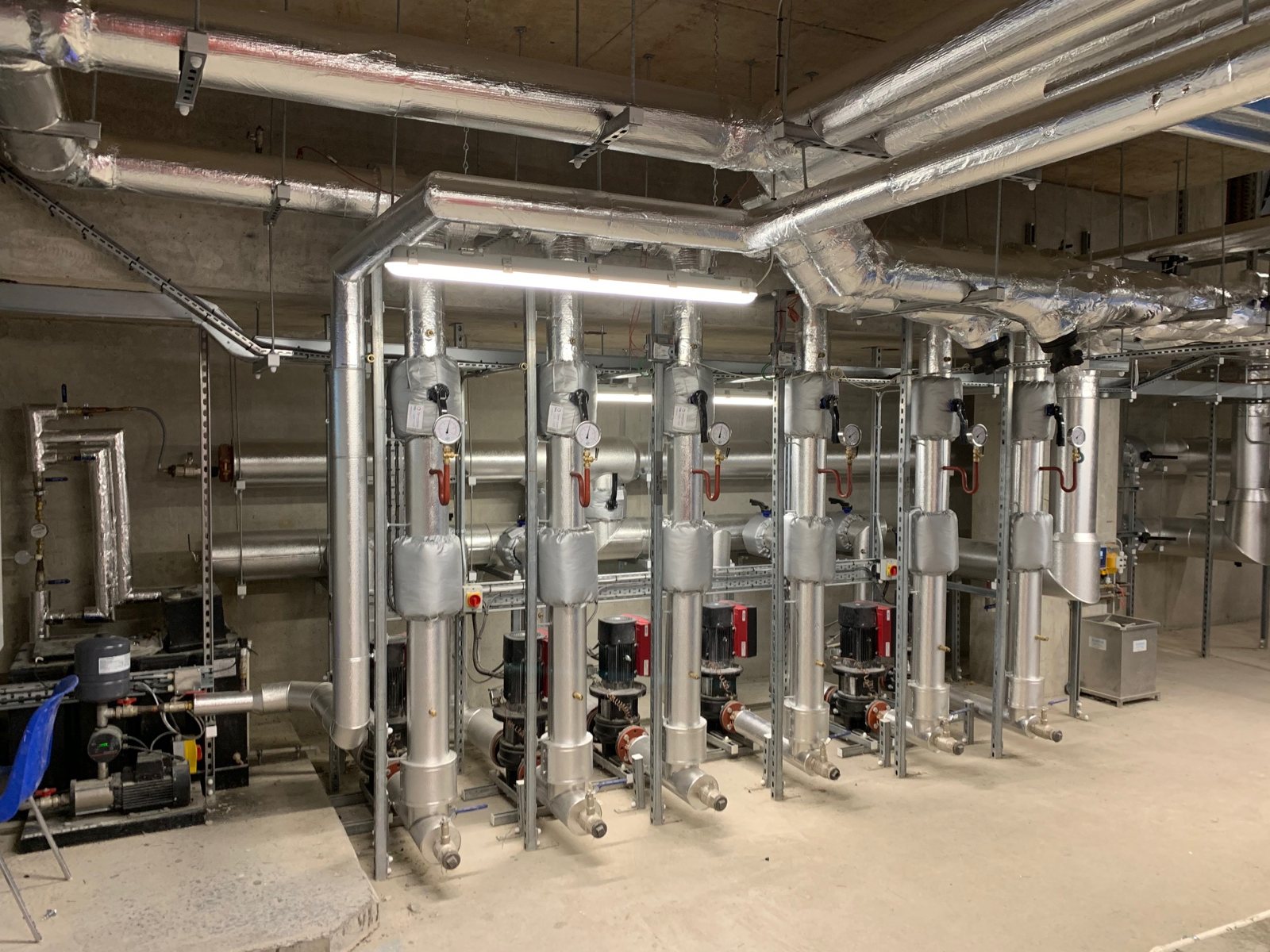 Metal-clad insulation on plant-room headers, vertical branches and fittings.