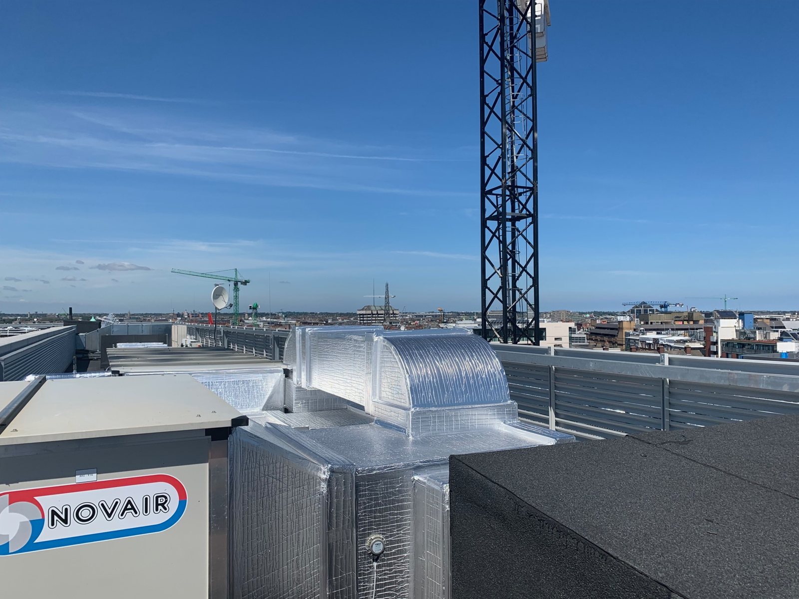 Formed metal cladding at a roof-level ductwork bend.