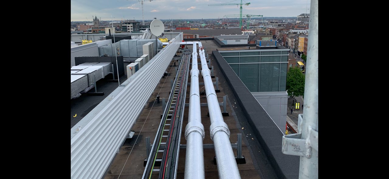 After insulation was fitted to the same rooftop pipe runs; this view shows the insulation stage.