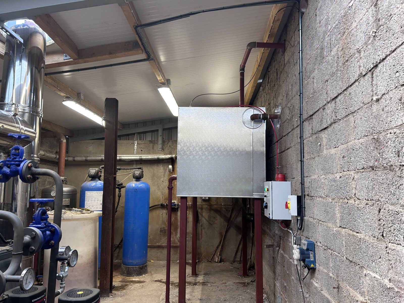 Cladding detail around a raised tank and adjoining plant-room services.