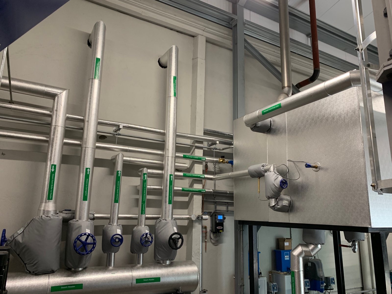 Insulated vertical services with removable covers at valves and connections.