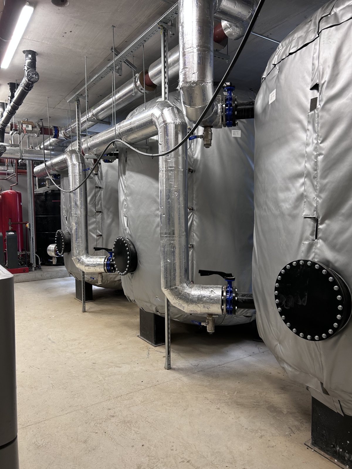 Large removable insulation covers fitted around cylindrical vessels and access points.