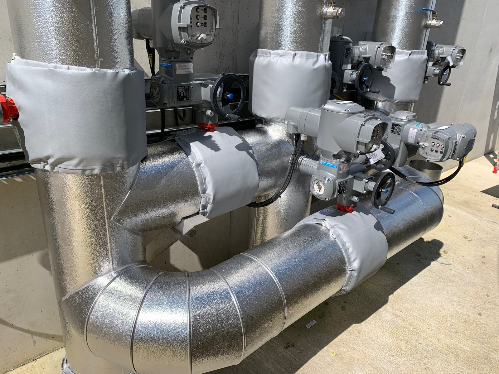 Clad pipework and removable covers around valves and fittings.
